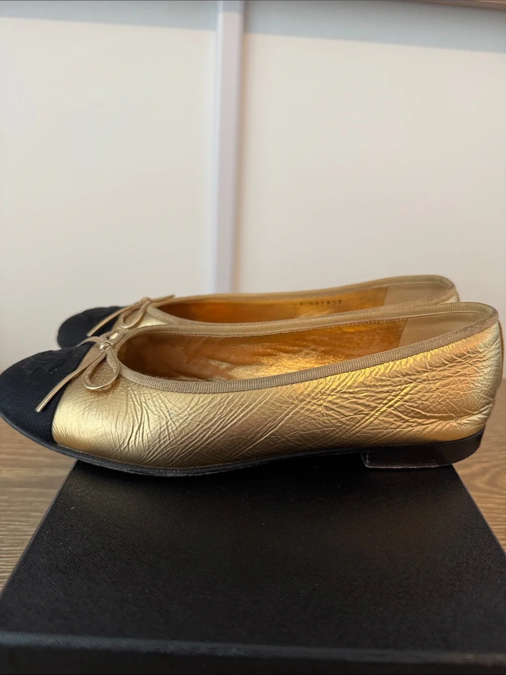 CHANEL Gold Leather Ballet Flats with Black Cap-Toe